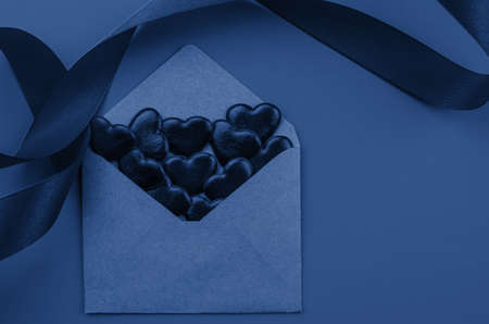 Valentine's day.Envelope with red hearts on Brown wooden background.の写真素材