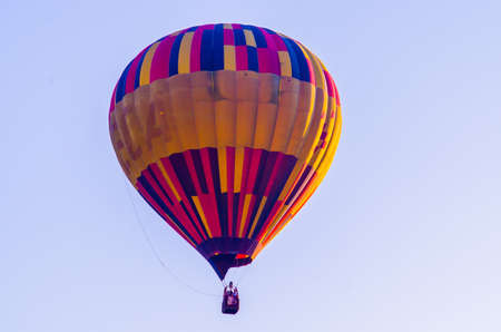 hot air balloon is flying at sunriseの写真素材