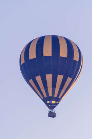 hot air balloon is flying at sunriseの写真素材
