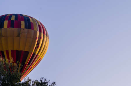 hot air balloon is flying at sunriseの写真素材