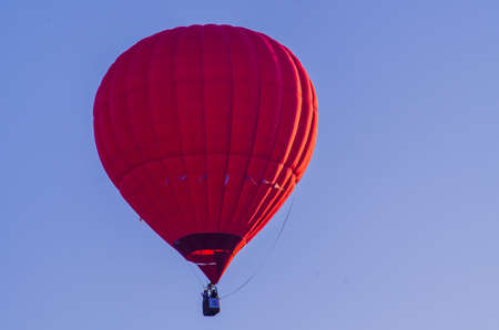 hot air balloon is flying at sunriseの写真素材