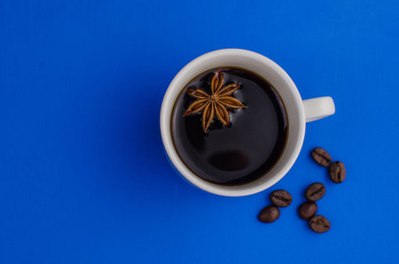 Cup of Coffee espresso with offee beans on blue background. Flat lay, creative design. Morning black coffee mood concept.の写真素材