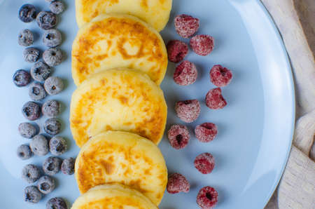 Cheesecakes in a blue dish with frozen fruit. Homemade, delicious food. Copy space for textの写真素材