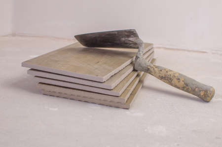 Trowel on the tiles for floors and walls on white background.の写真素材