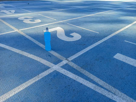 Isotonic energy drink. Bottle with blu transparent liquid, sport beverage on a sports ground. Start for running.の写真素材