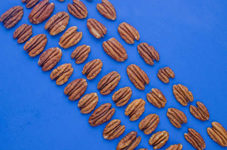 pecan nut on a blue background. concept of healthy eatingの写真素材