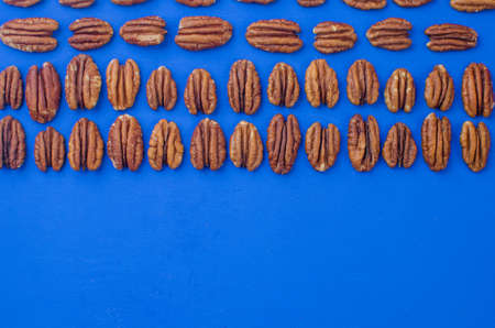 pecan nut on a blue background. concept of healthy eatingの写真素材