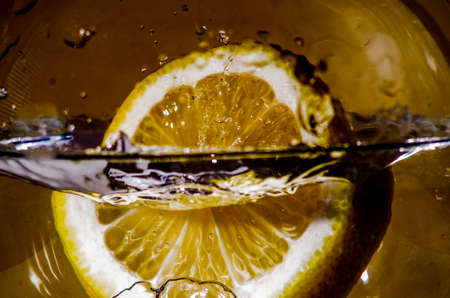 An orange falling into the water. Bright background. Close upの写真素材