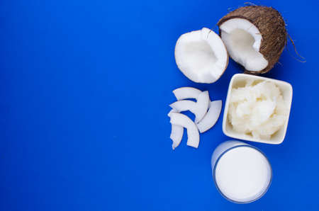 Natural coconut milk, coconut shavings, coconut chips on a blue background. The concept of healthy food.の写真素材