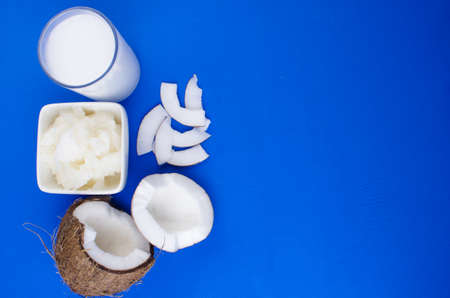Natural coconut milk, coconut shavings, coconut chips on a blue background. The concept of healthy food.の写真素材