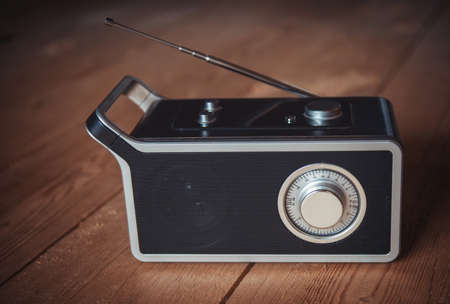 Vintage radio with a telescopic antenna on a wooden floor.の写真素材