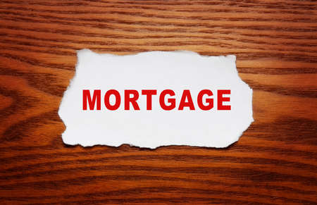 Mortgage concept. The word mortgage on a piece of paper on a wooden background.の写真素材