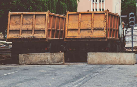 A row of yellow heavy dump trucks, view from the rear.の写真素材