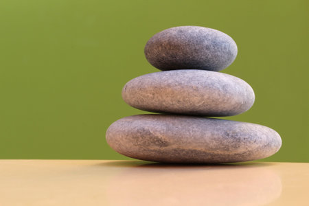 Three stones on a green background - harmony, stability, simplicity, peace
