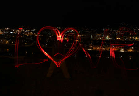 Blur photo made with red bike lamps  Sign love with heart before city の写真素材