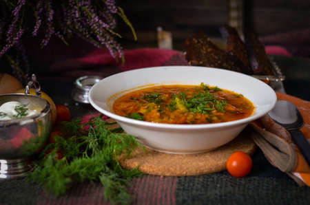 Traditional ukrainian vegetable soup with sour cream and rye bread. National cuisine. Borscht. Soup with tomato, carrot, onion and potato. Rustic food backgroundの写真素材