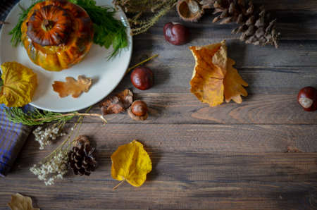 Pumpkin baked with meat on rustic wooden background, fall leaves. Top view point. Thanksgiving cozy vintage border background. Selective focusの写真素材