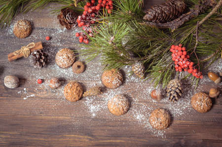 Christmas and New Year Decoration with Pine Branches, Oatmeal Cookies, Gingerbread, Rowan, Walnuts, Fir Cones, on a Rustic Wooden Table, Copyspace Backgroundの写真素材