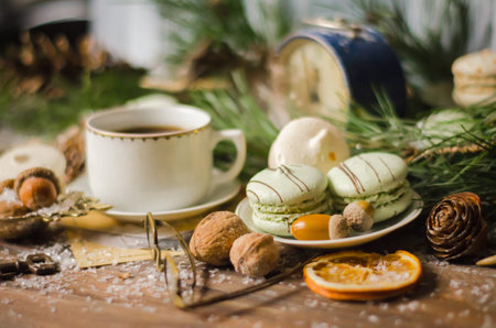 Christmas and New Year A Cup of Coffee with Macaroons, Vintage Alarm Clock, Pine Branches, Antique Glasses, Walnuts, Fir Cones, on a Rustic Wooden Tableの写真素材