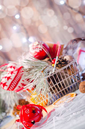 New year and Christmas winter decoration on rustic white wooden background with snow covered fir branches, tangerines, cones and shopping cart full of gifts. Copy space backgroundの写真素材