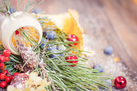 Festive scene with fir branches, blueberries, Christmas balls in a powdered waffle cone on rustic wooden background, Copy space, vintage decorationの写真素材