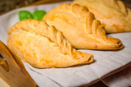 Pastry stuffed with minced meat and onion on rustic background. Karaite kibinai - Lithuanian...