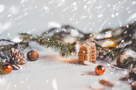 Background of arrangement of cookies and small baubles with spruce branch in snow. の写真素材