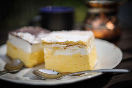 Rustic breakfast. Wooden coffee table with coffee cups, cezve, lake Bled cream cake, delicious slovenian dessert.の写真素材