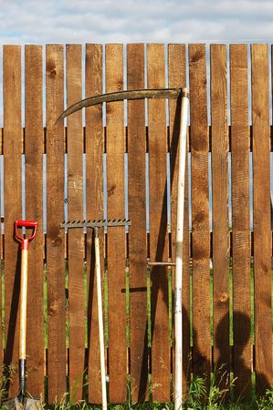 garden tool set over wood backyard fenceの写真素材