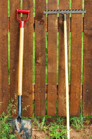 garden tool set over wood backyard fenceの写真素材