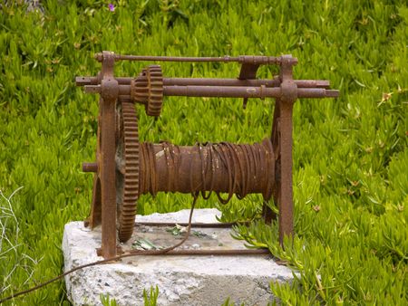 rusty winch and green succulent plants backgroundの写真素材