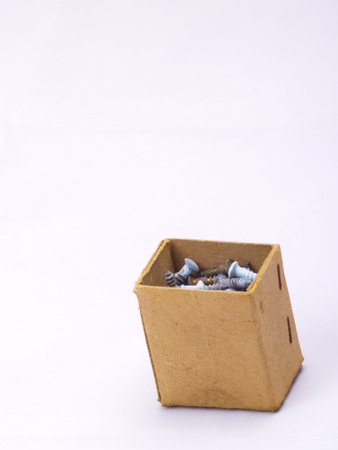 old grungy cardboard box with brass screws on off-whiteの写真素材
