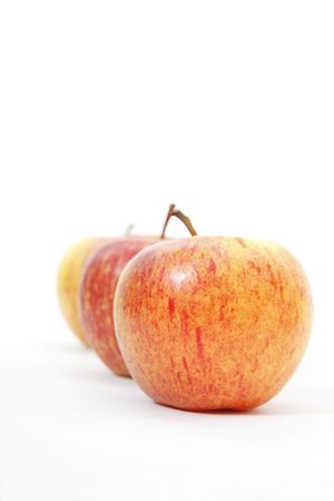 three red and yellow apples on whiteの写真素材