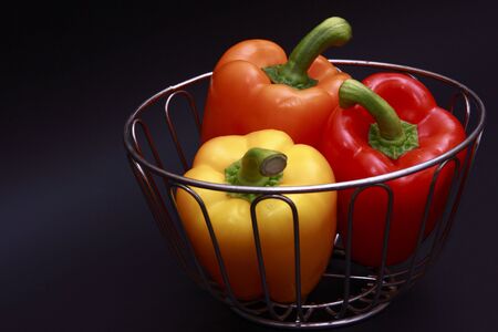 three bell peppers in chrome basketの写真素材