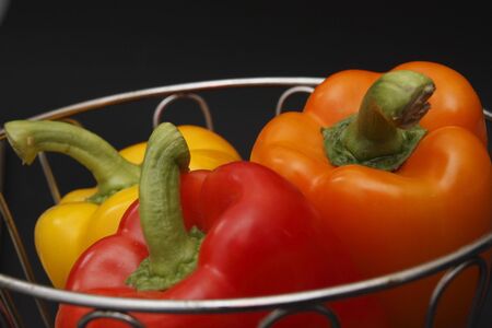 three bell peppers in chrome basketの写真素材