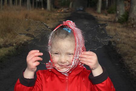 little girl looking through a plate of ice having fun, when seeing the world blurredの写真素材