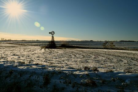 Abandoned windmill in snow covered corn fieldの写真素材