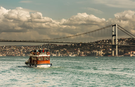 tourist ship visiting Bosphorus Bridge Istanbul Turkey at cloudy day and blue skyの写真素材