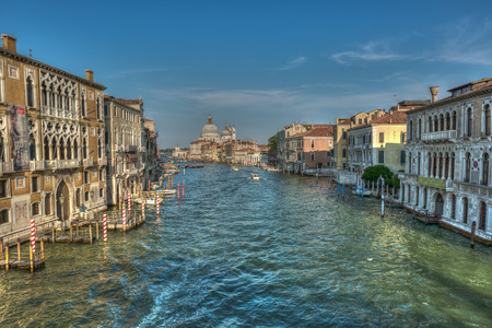 Buildings and traditional Venice gondolas riding on canal in Venice Italy at sunny summer dayの写真素材