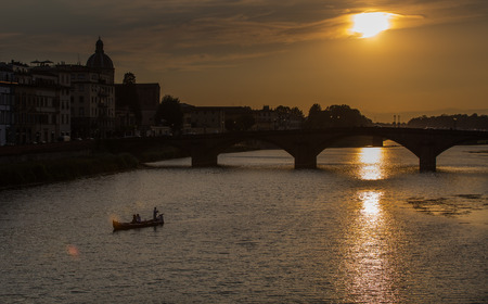 A view of Ponte Vecchio bridge on sunset time and Arno river in Florence. Tuscany, Italyの写真素材