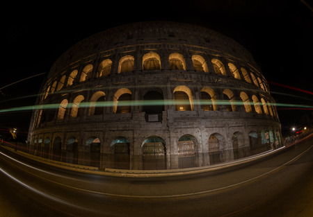 A night view of Colloseum and city traffic in rome italyの写真素材