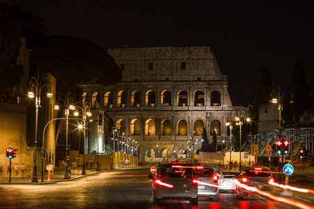 A night view of Colloseum and city traffic in rome italyの写真素材