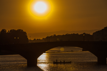 A view of Ponte Vecchio bridge on sunset time and Arno river in Florence. Tuscany, Italyの写真素材