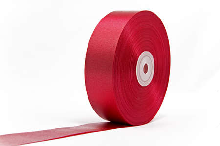 A roll of shiny red ribbon unrolled like a giant red carpet の写真素材