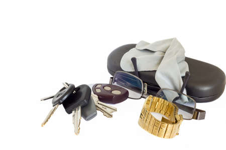 Car keys with an alarm remote next to a pair of glasses, a watch and a caseの写真素材