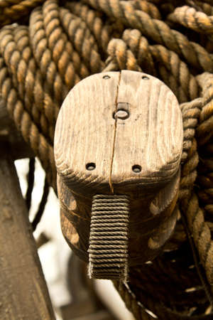 An old rope and wooden block pulleys of an old pirate shipの写真素材