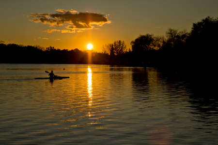 Beautiful sunset over lake Wascana with reflection of the sun on the waterの写真素材
