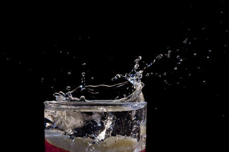 The motion of a slice of apple splashing into a glass of waterの写真素材