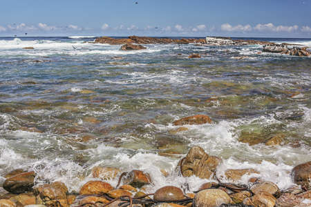 The beautiful clear waters of the Atlantic ocean with its rocky coastline near Cape Town in South Africaの写真素材
