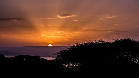 The sun rising behind the hills over lake Langano in Ethiopia の写真素材